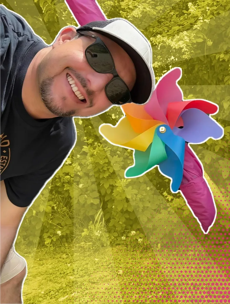 Michele Marmentini, fondatore di MA! Creative Studio, sorride accanto a una girandola colorata